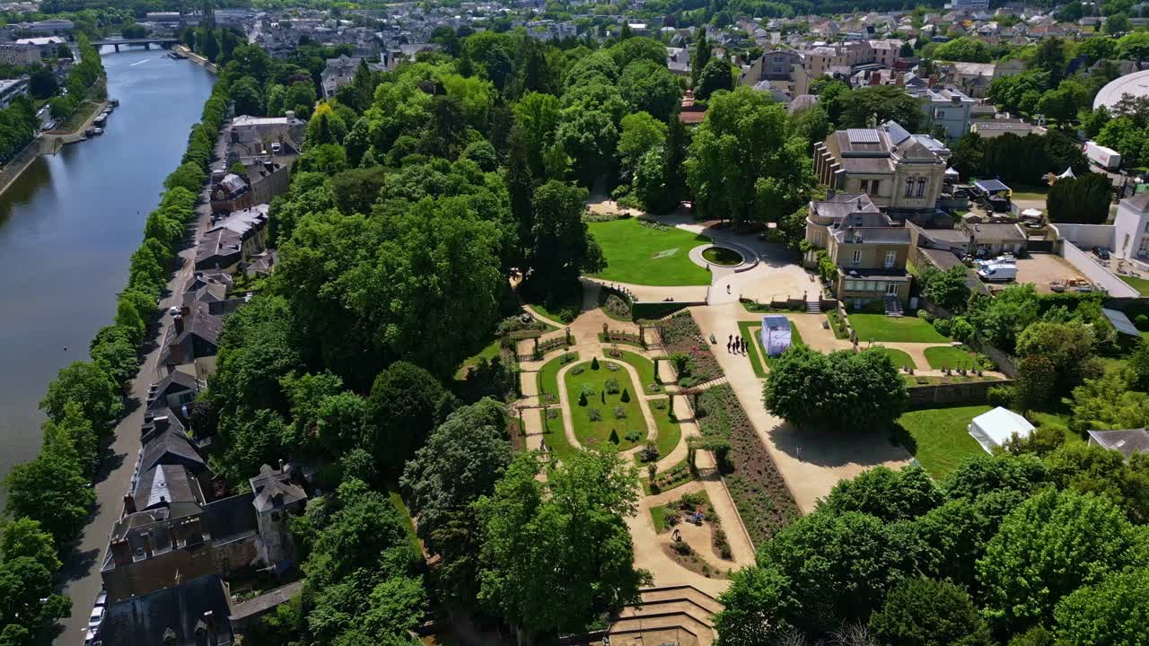 Jardin de la Perrine in Laval with trees, Mayenne river and cityscape in France. Aerial drone sideways