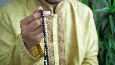 muslim man keep hand in praying gestures during ramadan, close up