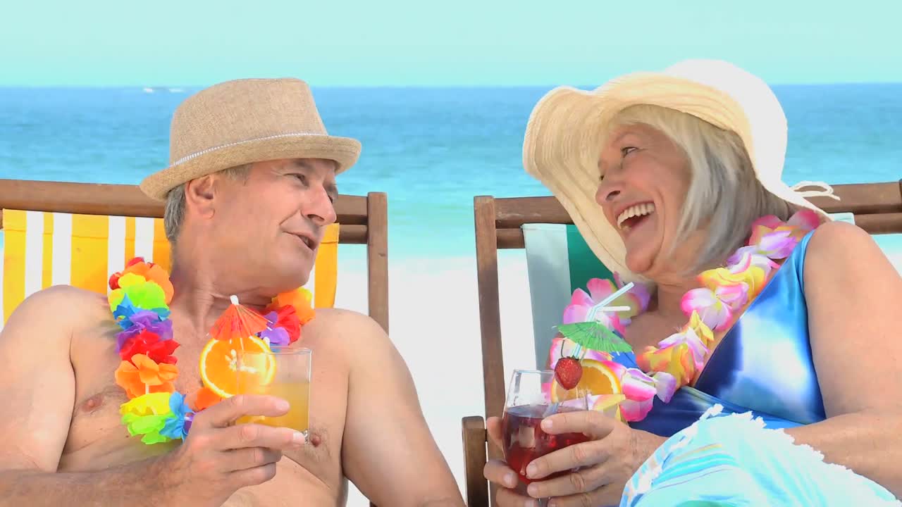 노인 부부가  ⁇ 테일과 함께 토스팅하고 있습니다.