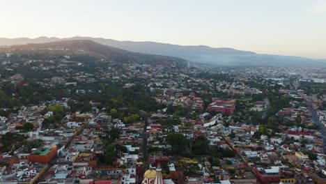 Drone-Reveals-Colorful-San-Miguel-de-Allende-City-Center,-Mexico,-Mountain-Landscape-in-Background