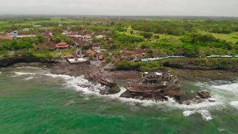 Amplia-Toma-Aérea-Del-Popular-Templo-Pura-Tanah-Lot-Y-Alojamientos-Turísticos-Cercanos