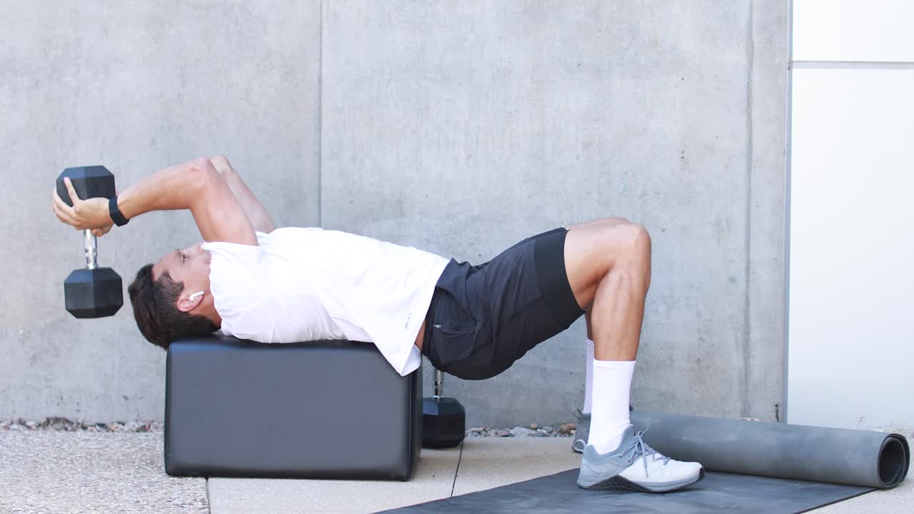 한 남자가 체육관에서 운동하는 동안 역기를 들고 운동한다 1