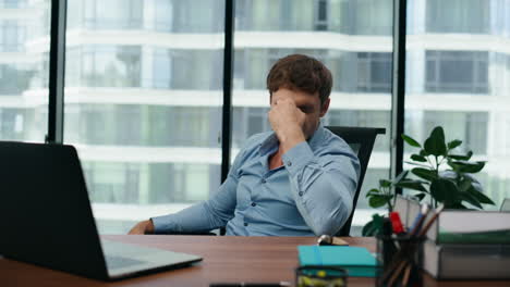 empleado sobrecargado de trabajo que se siente agotado en un largo trabajo de oficina en la computadora portátil de cerca.