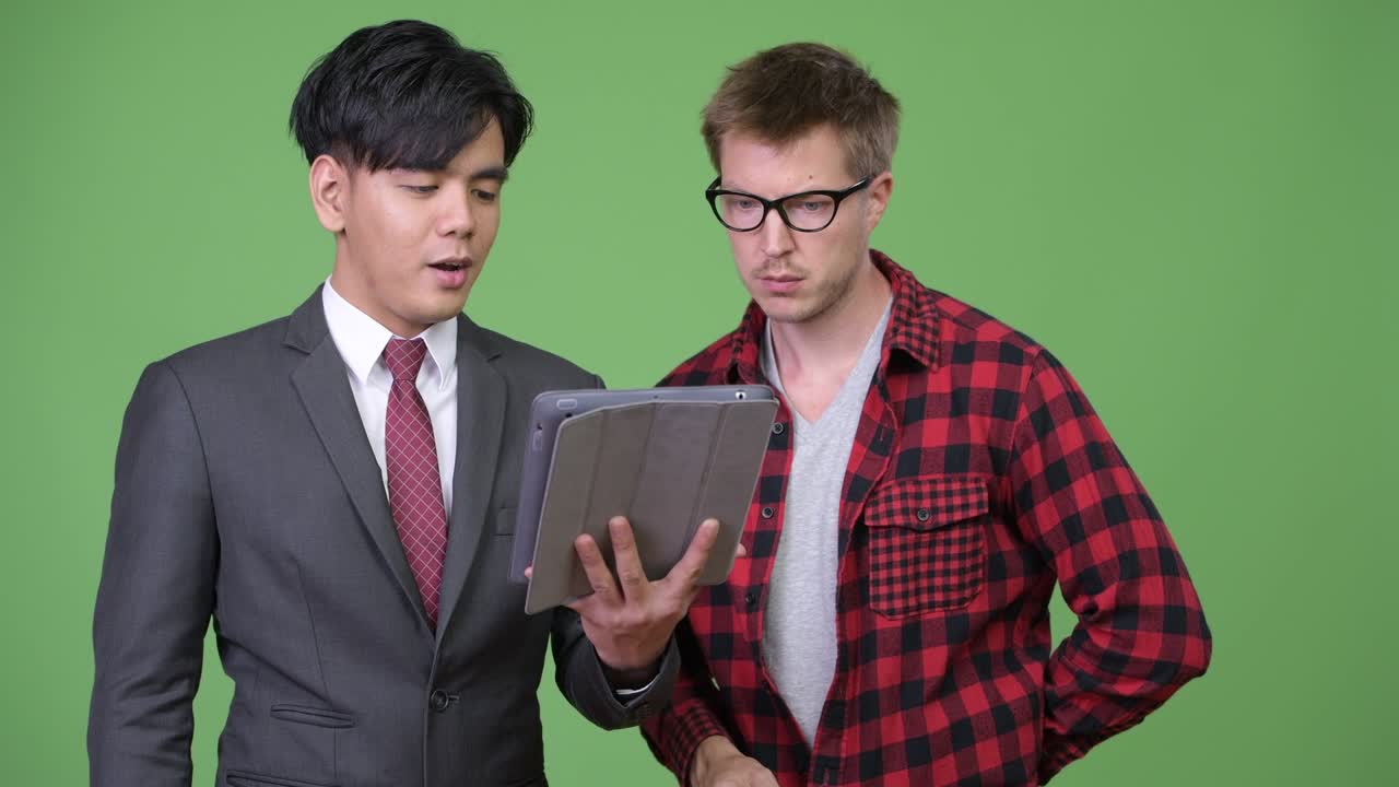 젊은 잘생긴 아시아 사업가와 젊은 스칸디나비아 사업가가 함께 일하고 있습니다.