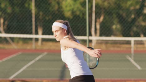 video of focused caucasian female tennis player holding racket and hitting ball