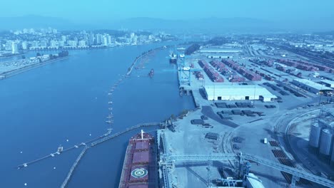 grain freighter loading for export aerial drone flyover on a sunny day as other ships are loading commercial industrial materials for national and international economy container ships 2-2