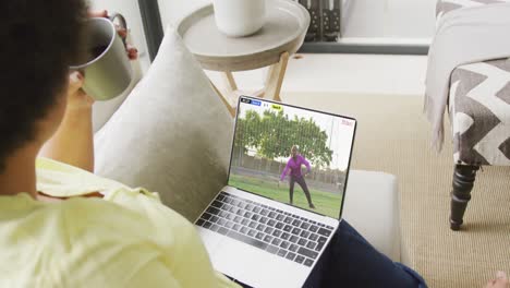 Video-Einer-Person,-Die-Auf-Der-Couch-Sitzt-Und-Sich-Ein-Fußballspiel-Auf-Dem-Laptop-Ansieht