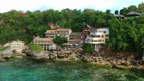 Scenic-Beachfront-Villa-On-A-Lush-Rocky-Hill-In-Bali,-Indonesia---Vacation-Destination---Drone-Shot