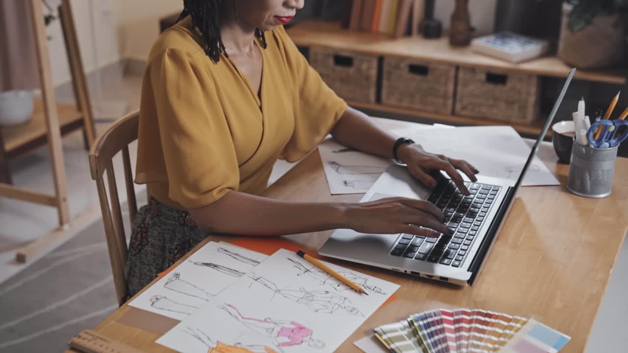 diseñadora de moda que usa una computadora portátil en el trabajo