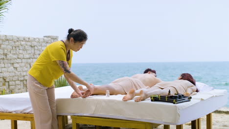 masseuse giving massage to couple