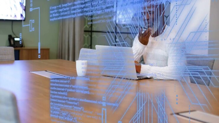 Manager right end table, typing laptop and speaking phone as tech overlays appearing for business