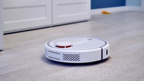 a robotic vacuum cleaner slides across the room.