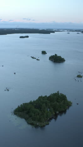 vertical drone shot in front of islands in the archipelago, evening in finland