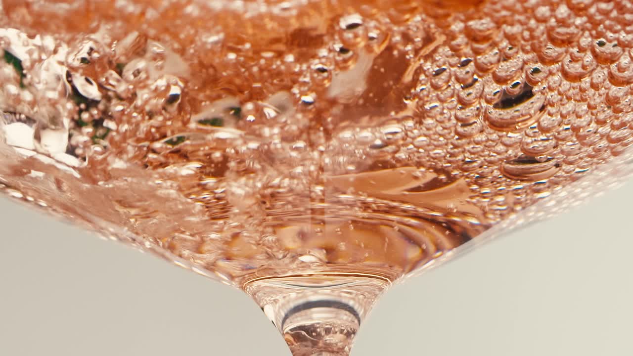 Orange or white wine bottle and glass against a sunset in a peaceful vineyard, pouring of ecological natural wine.