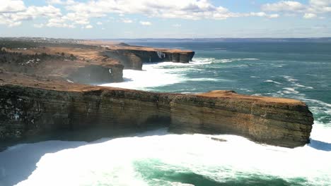 Drone-shot-of-coastal-cliffs-being-smashed-by-waves