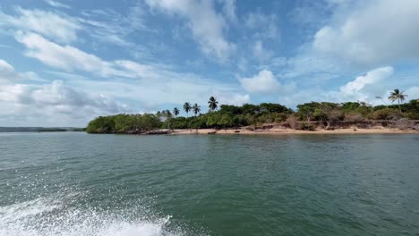 toma giratoria que pasa rápidamente por la tropical y aislada playa de muquiço desde el puerto de un barco en la laguna de guaraíras en tibau do sul, brasil en río grande do norte durante un cálido día soleado de verano