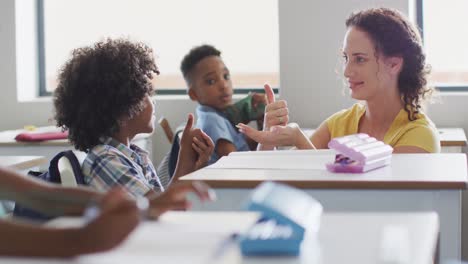 video de una feliz maestra caucásica enseñándole matemáticas a un niño afroamericano