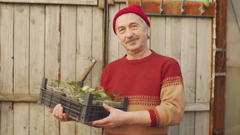 portrait of senior man with flowers in greenhouse farm