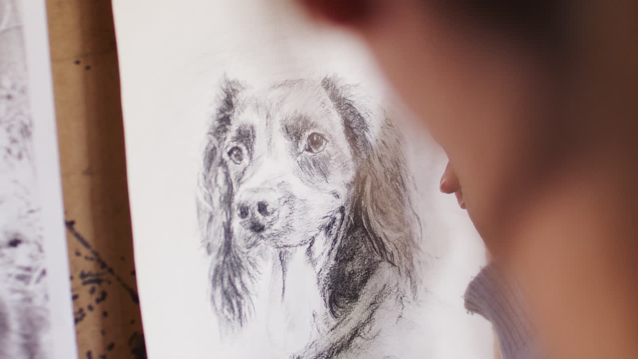 Close Up Of Artist Sitting At Easel Drawing Picture Of Dog In Charcoal