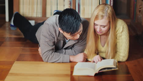 dos estudiantes leen un libro en la biblioteca 02