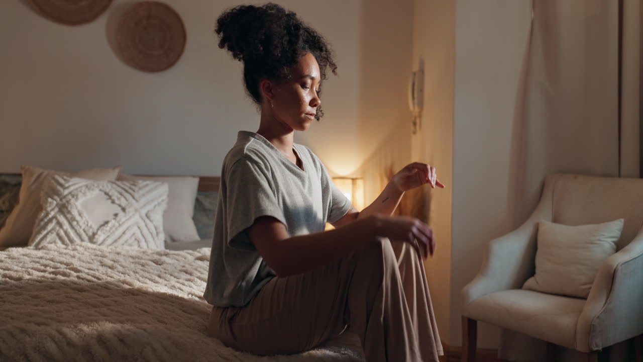 Woman sitting on bed in bedroom