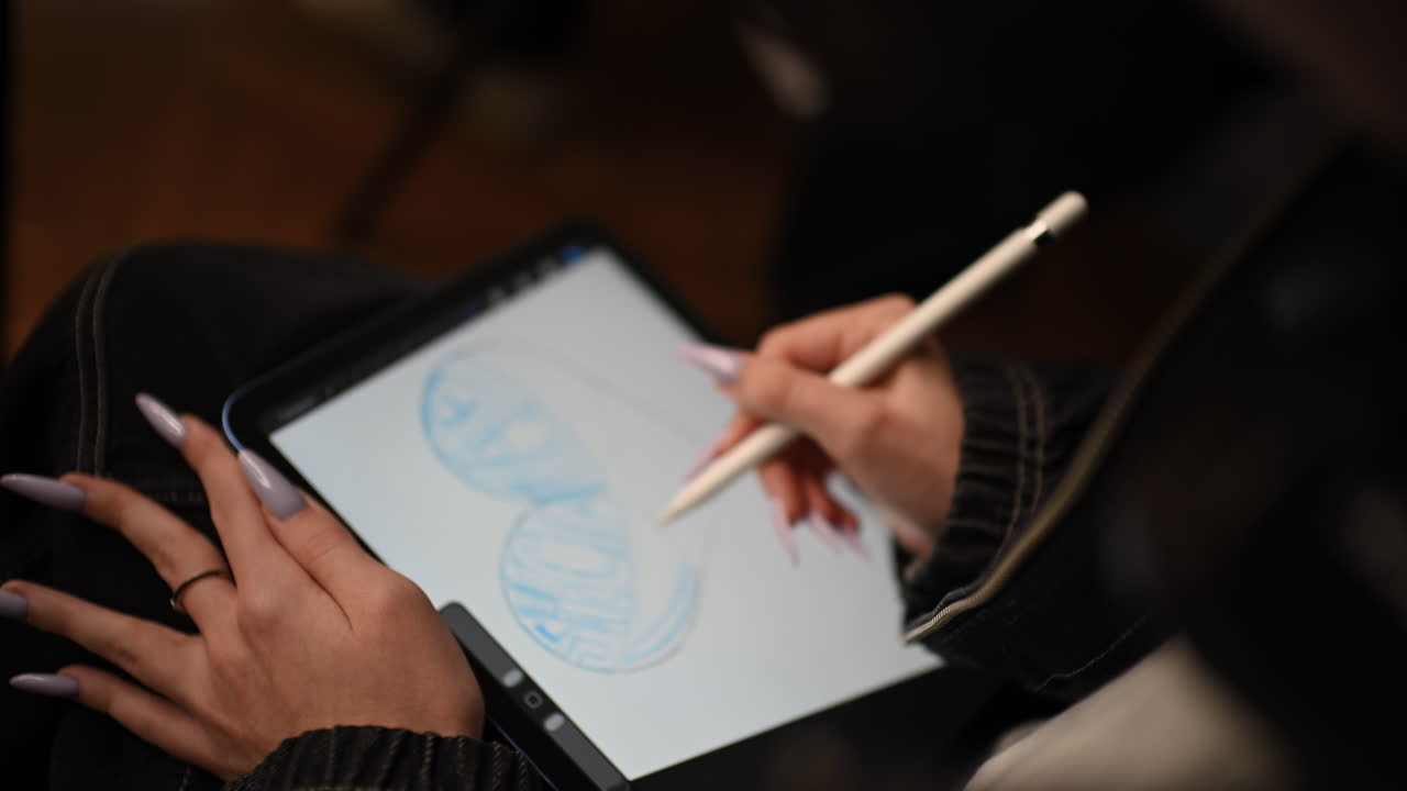スタイラスペンを使ってデジタルタブレットに描く女性のクローズアップ