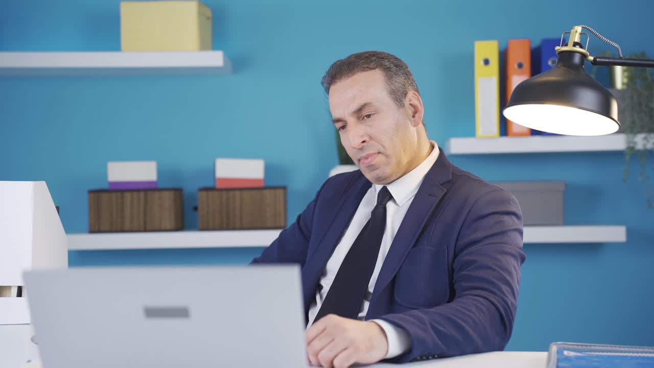 Uomo d'affari frustrato e stressato che guarda lo schermo del computer preoccupandosi per un problema