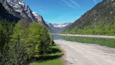 Water-stream-with-sandy-shores-and-mountains-in-the-background