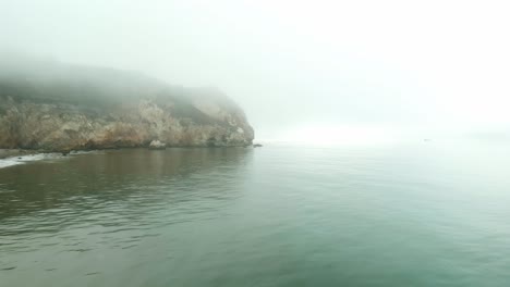 scenic steep cliffs at california coastline on a foggy day, aerial view