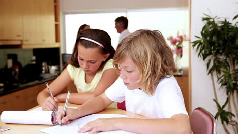 siblings doing their homework in the kitchen with their parents behind them