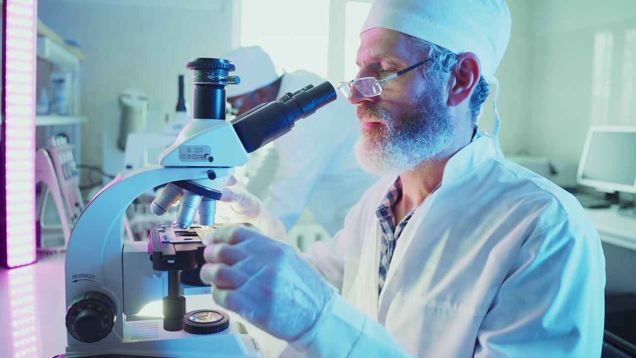 Male Scientist Looking Through Microscope in a Modern Laboratory