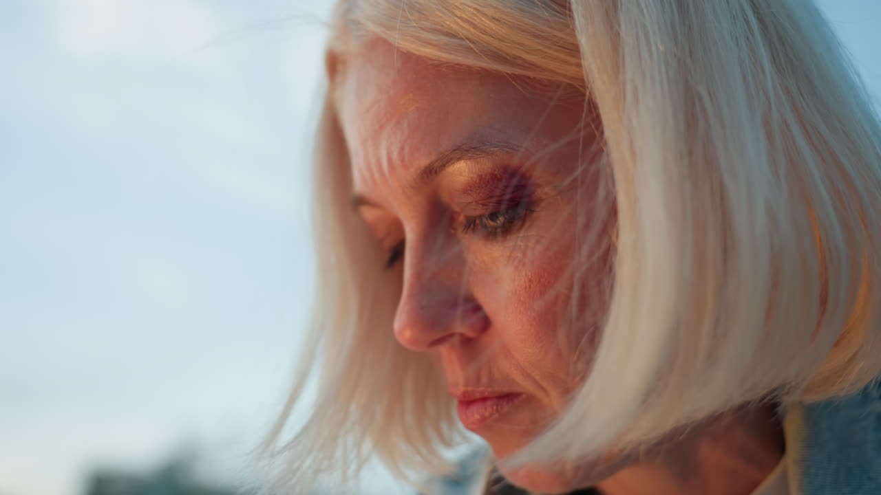 close up bob hairstyle woman deeply focused painting outdoors, warm sunlight casting highlights across face as wind gently moves strands, capturing intense concentration and serene creative moment