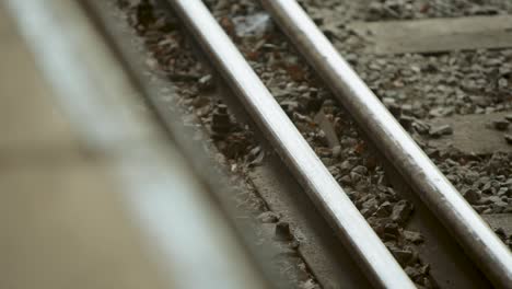 Close-up-panning-shot-of-train-tracks-with-detailed-textures-of-gravel-and-metal,-creating-an-industrial-feel