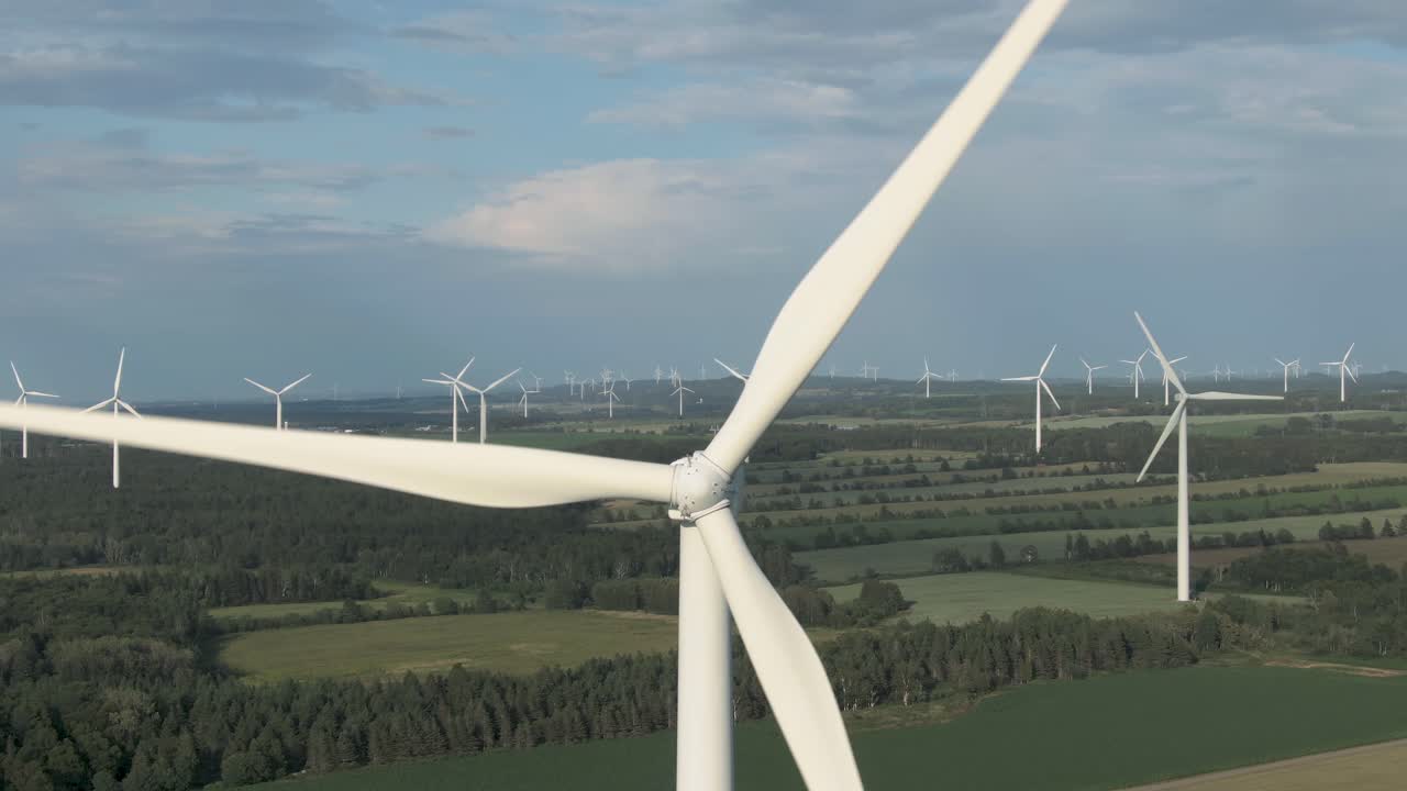 Wind Farm Situated On The Lush Fields With Blue Sky Above On Summer In Northern Quebec, Canada. - close up - aerial