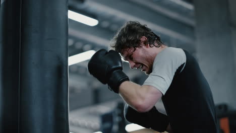 kickboxer agresivo mostrando fuerza en el gimnasio. deportista boxeando en el club deportivo