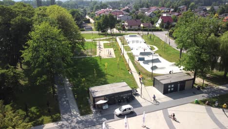 Young-People-Biking-And-Skating-At-Skatepark-On-Sunny-Day-In-Krakow,-Poland