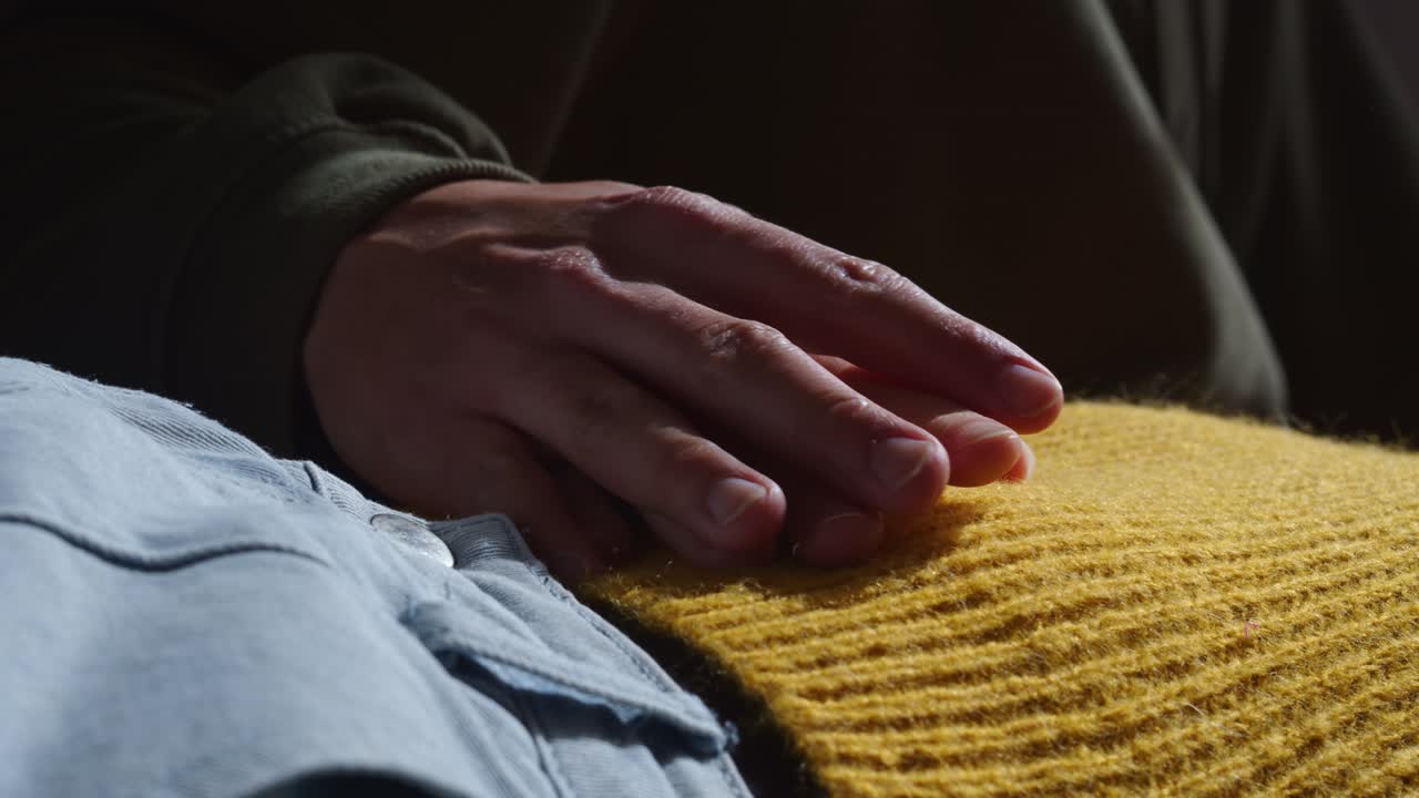 A Husband Holds the Hand of His Wife as She Lies Down - Close Up