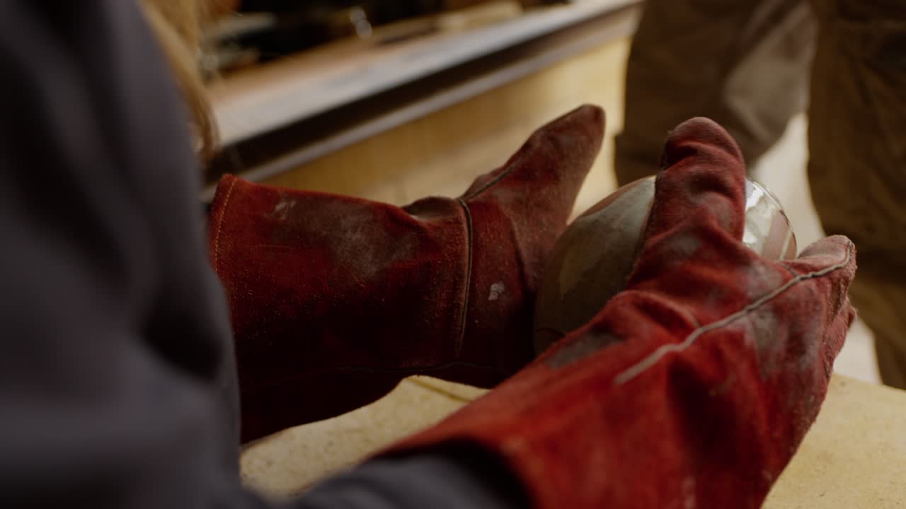 Potter's hands examining a finished ceramic bowl, craft and art of pottery