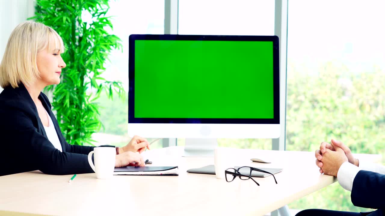 Persone d'affari nella sala conferenze con schermo verde