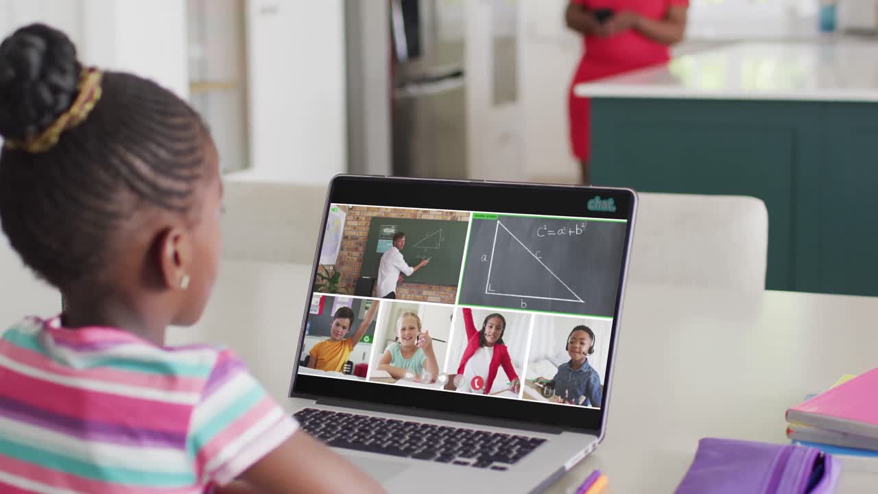 escolares diversos teniendo una llamada de video portátil con un profesor masculino y levantando las manos en cámara lenta