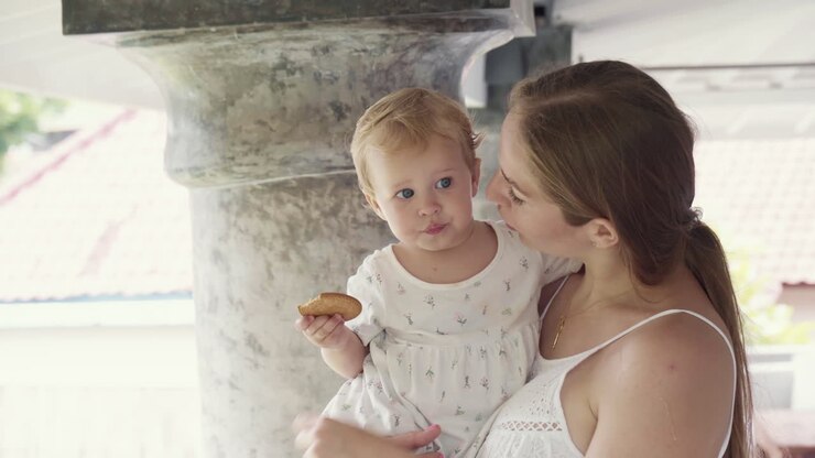 madre con el bebé sosteniendo una galleta