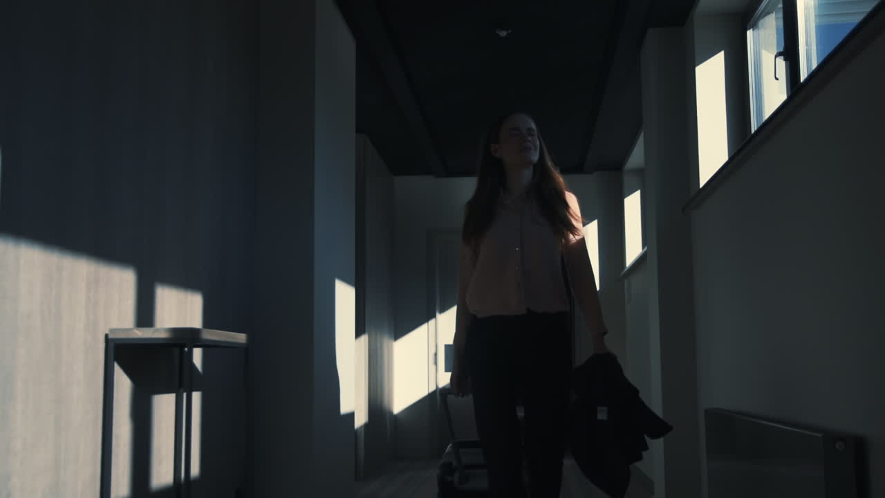 여행 가방 을 들고 호텔 복도 에서  ⁇ 고 있는 사업가 여자