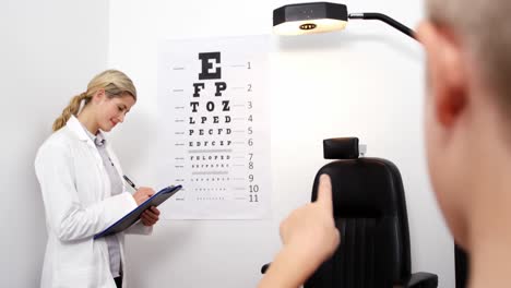 Female-optometrist-taking-eye-test-of-young-patient