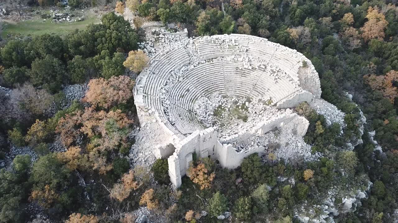 Drone shot, Flying over ancient amphitheater in Termessos, Turkey. Old ruins and nature at the 1000m above sea level.