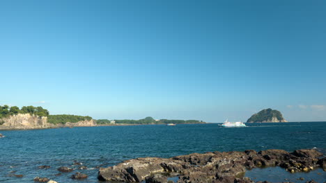 luxury tourist ferry boat traveling on jeju island with volcanic rocky shore in south korea