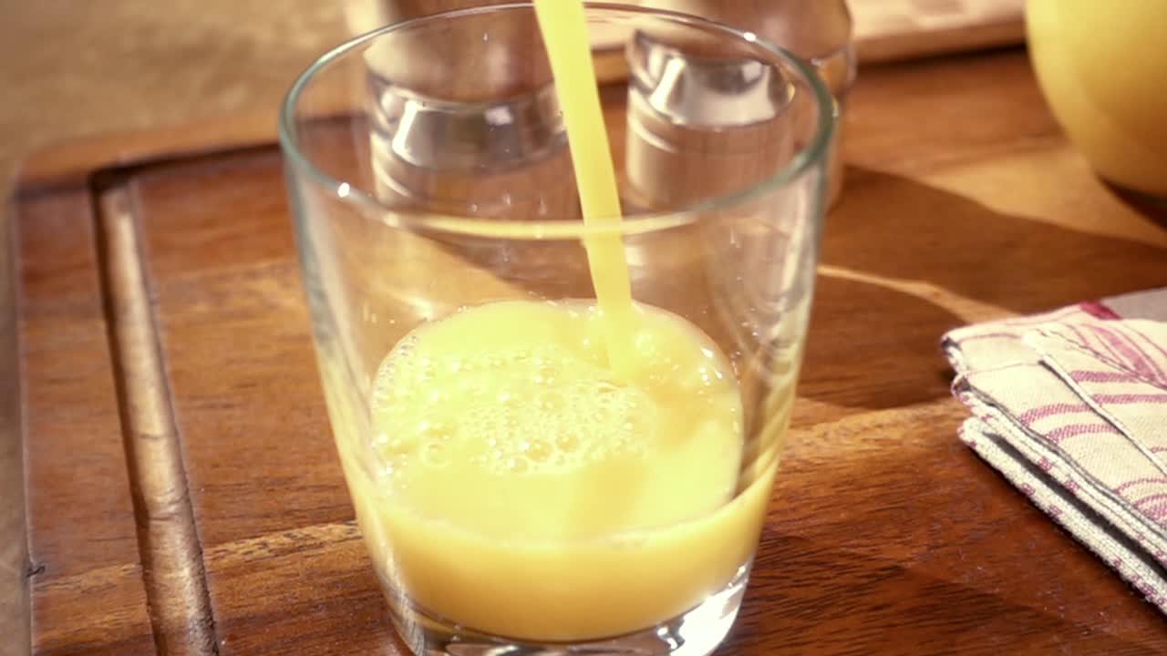 오렌지 주스가 잔에  ⁇ 어지는 것, 아침 아침 식사, 회전 추적 촬영과 함께 느린 동작.