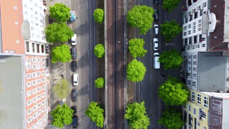 wide road between houses canyons cars driving next to the subway track wonderful aerial view flight drone camera pointing down footage of berlin prenzlauer berg schönauer allee 2022 by philipp marnitz