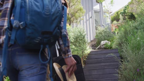 pareja feliz diversa con equipaje y sombreros caminando por las escaleras