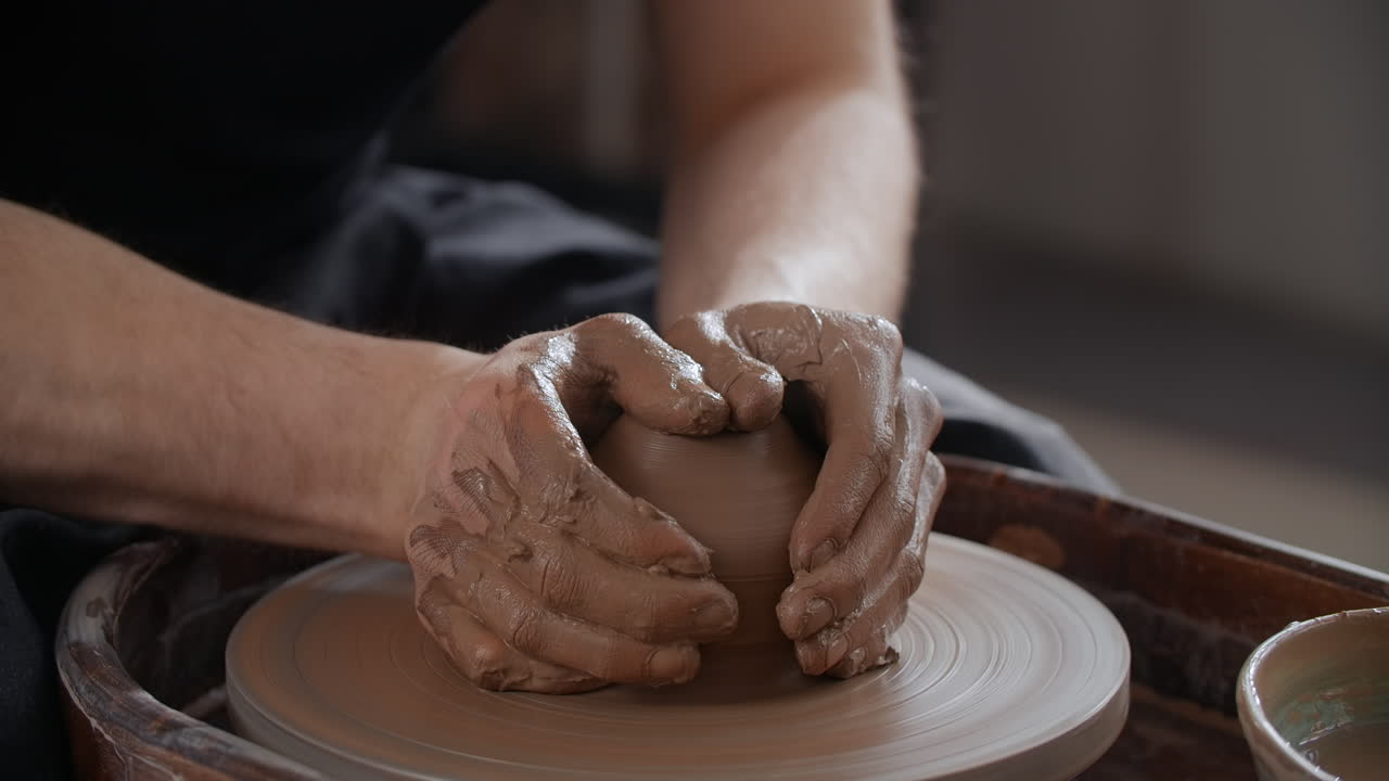 persona que da forma a la arcilla en una rueda de cerámica