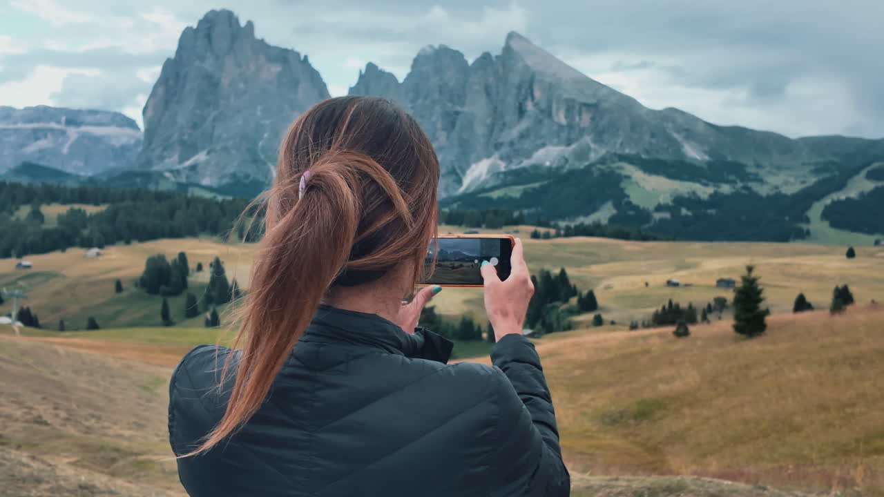 Tourist taking pictures of the landscape in Alpe di Suisi, Dolomites, Italy in slow motion